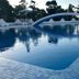 Hotel Lodos in Karterados with a blue outdoor pool and arched bridge at dusk