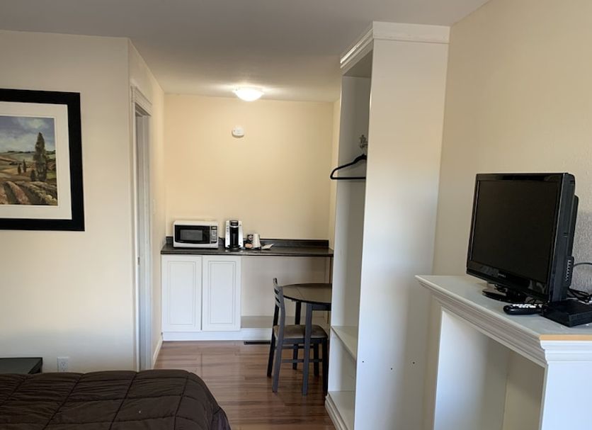 Langham Motel guest room with bed, TV, kitchenette and small dining table in Langham