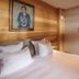 Pêche De Vigne & Spa in Rodern bedroom with white bed, wood walls and framed portrait