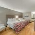 Red Roof Inn Kingsport guest room with two double beds, wood flooring, chair, and dresser