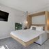 The St Laurent Guest Rooms in Asbury Park: modern room with floating bed, wall-mounted TV, and pendant lights
