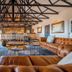 Gondwana Etosha Safari Lodge lounge in Okaukuejo with leather sofas, bar, and exposed beam ceiling