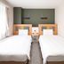 Comfort Hotel Narita twin room with two single beds and a window with sheer curtains in Narita