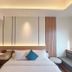 Lamora Kota Lama Surabaya guest room with bed, desk, and warm wood paneling