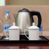 Long Ge Hotel, Beijing: in-room kettle tray with cups and bottled water on a sofa-side table
