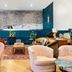 Arrive Memphis lounge in Memphis with teal walls, velvet chairs, patterned rugs, and a large wall mural
