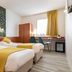Deltour Hotel Le Puy En Velay guest room with twin beds, desk, window and yellow accents in Le-Puy-en-Velay