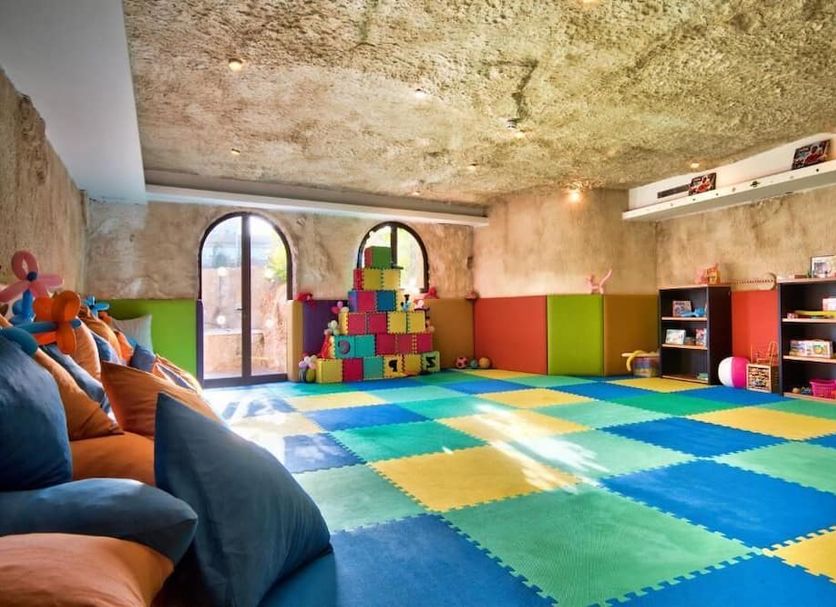 Db Seabank Resort And Spa in Mellieha kids' playroom with colorful foam mats, toys, and arched windows