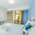 Thassos Olivia Resort room in Potos with twin beds, TV, desk, and blue accent wall
