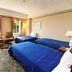 Hotel Den Haag Huis Ten Bosch guest room in Sasebo with two twin beds, seating area and large windows