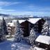 Hotel La Prairie in Crans-Montana, snow-covered chalets and pine trees with mountain views