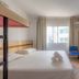 Mar Hotel Balneário Camboriú guest room with twin beds, large window, and open shelving