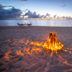 Sailrock South Caicos beach bonfire at sunset with lounge chairs and ocean view, Cockburn Harbour