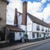 Dog and Partridge by Greene King Inns in Bury St. Edmunds on a quiet street, with a white facade and flower boxes.