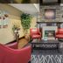 Red Roof Inn & Suites Knoxville East lobby lounge with red chairs and stone fireplace in Knoxville