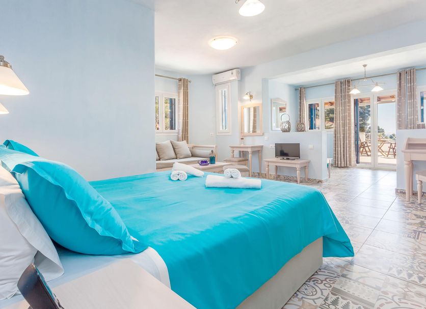 Stafylos Suites & Boutique hotel in Stafylos room with turquoise bedspread and bright sitting area