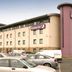 Premier Inn Newcastle Airport hotel exterior in Newcastle upon Tyne with parking lot and parked cars