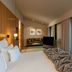 Memmo Principe Real Lisbon guest room with king bed, seating area, and city view through floor-to-ceiling windows