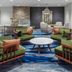 Fairfield Inn & Suites by Marriott Rapid City lobby seating area with green chairs and round tables