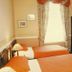Murrayfield Park Guest House in Edinburgh room with two single beds, wardrobe, and window curtains