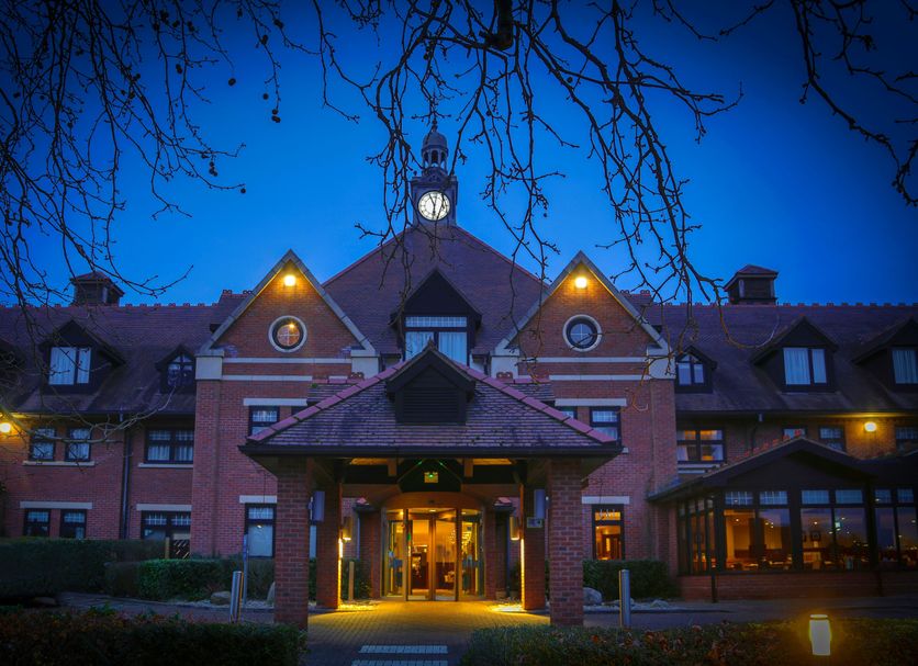 DoubleTree by Hilton Stratford upon Avon entrance at dusk with lit clock tower and covered drive