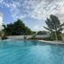 Aqua Resort, Diani Beach pool with palm trees and a partly cloudy sky