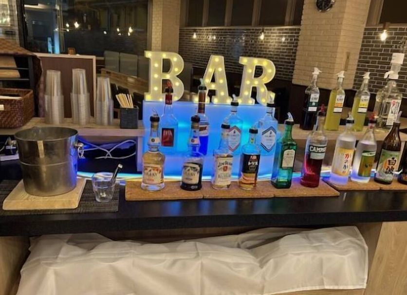 Hotel Prime inn Toyama bar area with liquor bottles, illuminated BAR sign, and ice bucket