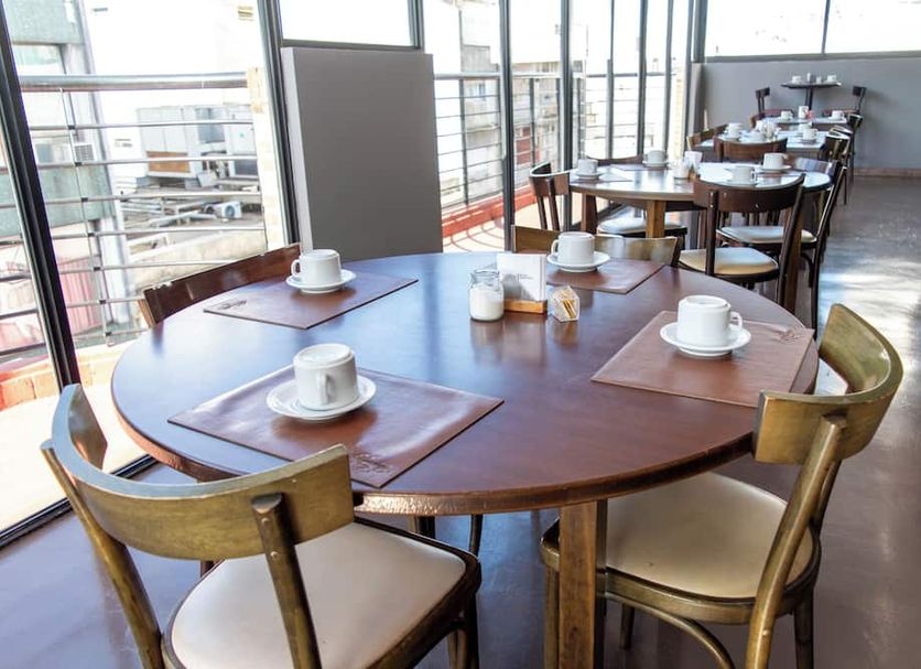 Duomi Hotel Buenos Aires dining area with round tables and city-view windows in Buenos Aires