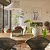 Basq House in Byron Bay dining area with woven chairs, wooden table, hanging lights and a plant centerpiece