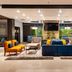 Courtyard by Marriott San Salvador lobby seating area with colorful chairs, sofas, plants and TV
