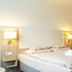 Hotel Kelkheimer Hof in Kelkheim guest room with double bed, bedside lamps and open wardrobe