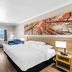 Days Inn by Wyndham Rockdale Texas guest room with king bed, twin bed, TV, and window view