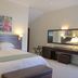 Clos Malverne Wine Estate Stellenbosch guest room with king bed, bench, desk and floral wall art