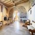 Tenuta Ciminata Greco in Rossano: rustic lounge with stone arches, fireplace, and seating area