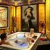 Schlosshotel Lacknerhof in Flachau: indoor spa tub with guests and artwork-lined wellness room