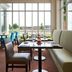 Hilton Garden Inn Montreal Airport dining area with large windows and tables overlooking greenery in Montreal
