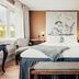 Stallmästaregården Hotel, Stockholm room with king bed, window seat and artwork