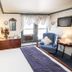 Rosewood Country Inn in Bradford: cozy guest room with four-poster bed, sitting chair, dresser, and window AC