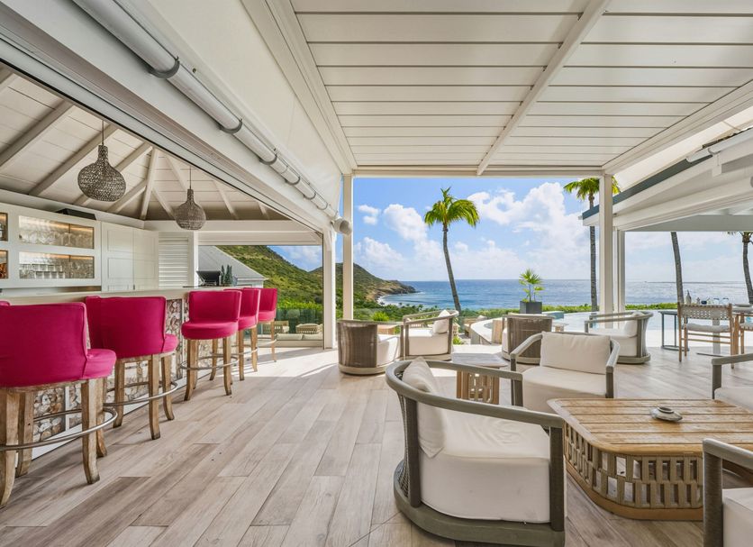 Hotel Le Toiny in Gustavia: open-air terrace with pink bar stools and ocean view