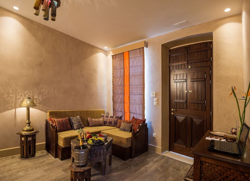 La Maison Ottomane in Chania interior lounge with corner sofa, wooden door and decorative table