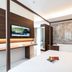 Hotel Milano Castello in Milan guest room with bed, work desk, wall TV and marble-style bathroom wall