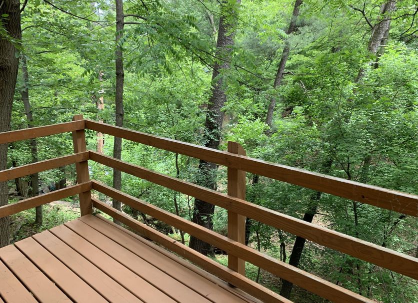 Lakeside Motel in Wisconsin Dells with a wooden deck overlooking lush forest trees