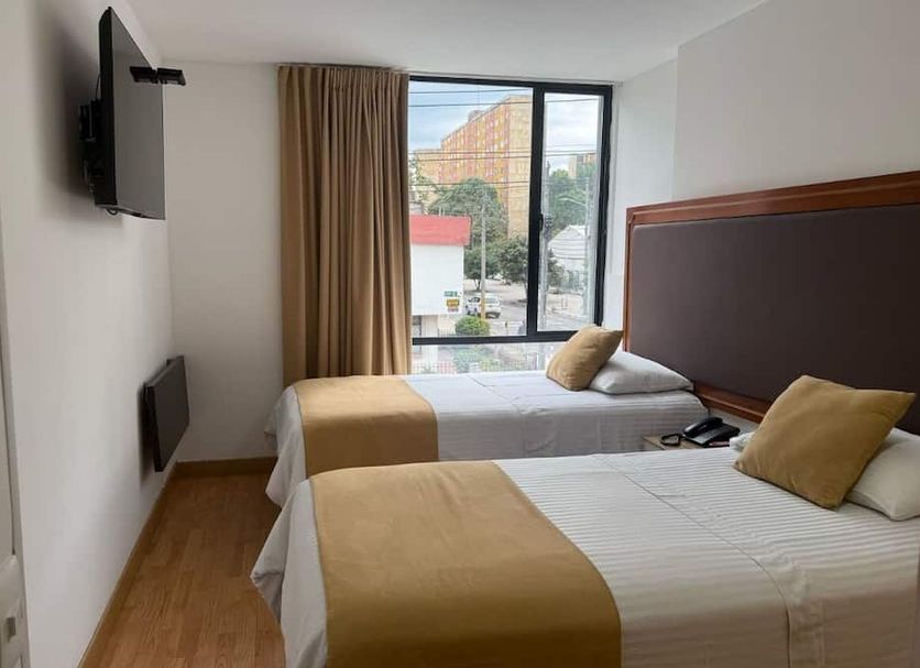Hotel Dorado Ferial Bogotá twin room with two beds and a street-facing window