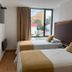 Hotel Dorado Ferial Bogotá twin room with two beds and a street-facing window