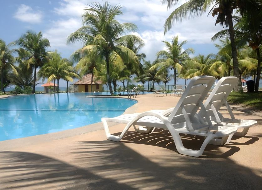 Gem Beach Resort in Kuala Terengganu with poolside loungers beside a tropical beachfront pool