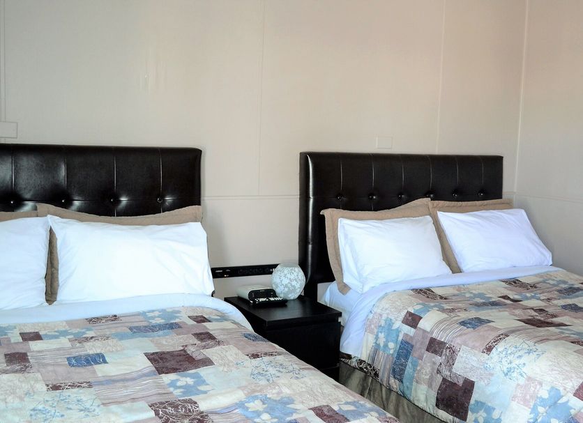 St. Paul Lodge in Saint Paul, twin beds with patchwork quilts and black headboards in a guest room