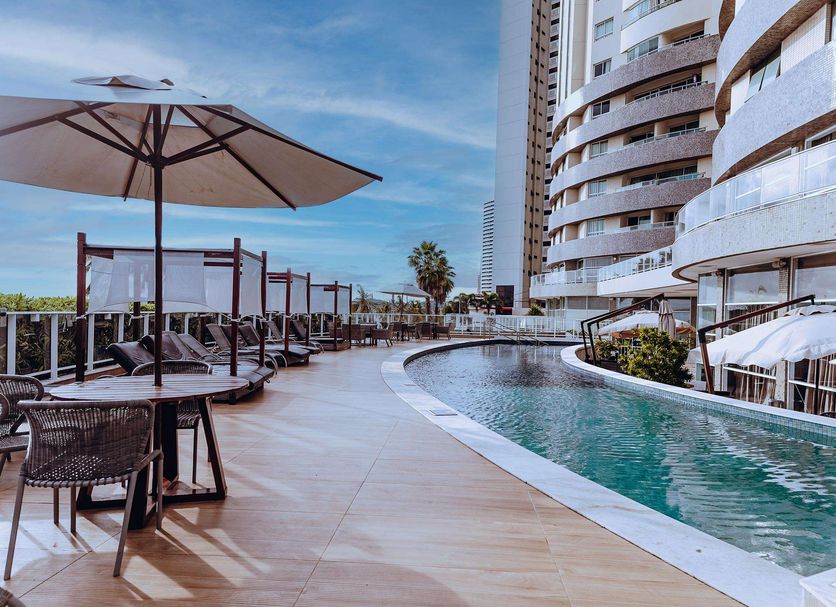 Golden Tulip Natal Ponta Negra poolside terrace with curved outdoor pool and oceanfront high-rise