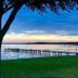 Candlewood Suites Kenedy By IHG waterfront lawn with tree and long pier at sunset
