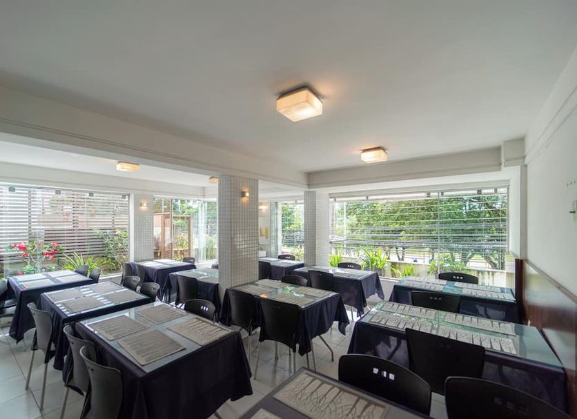 Lagoa Park Hotel in João Pessoa dining room with black tablecloths and large garden-view windows