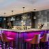Leonardo Hotel Madrid City Center bar with pink-lit counter and high stools in Madrid